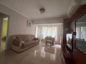 Salón con sofá y mesa de comedor junto a la ventana