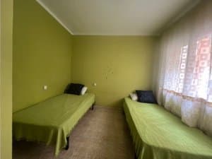 Dormitorio verde con dos camas individuales