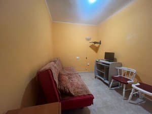 Sala de estar con sofá rojo y mueble