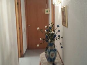 Recibidor con mesa auxiliar y jarrón de flores