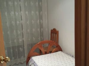 Dormitorio con cama individual y cortinas