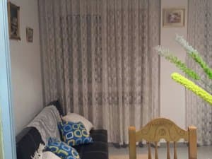 Salón con sofá y sillas de madera