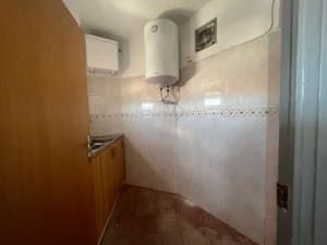 Cocina con muebles de madera y termo