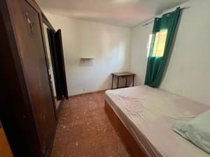 Dormitorio con cama y armario oscuro