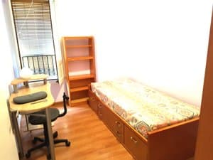 Dormitorio con cama individual, escritorio y estantería