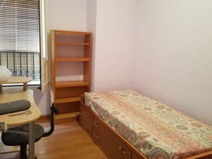 Dormitorio individual con escritorio junto a la ventana
