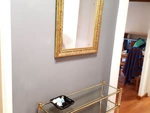 Recibidor con espejo dorado y mueble auxiliar
