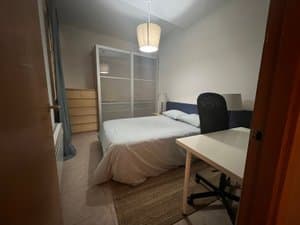 Habitación con cama doble, escritorio y armario