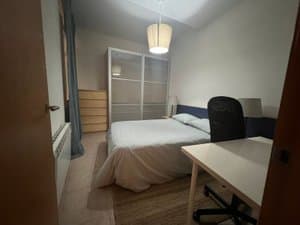 Habitación con cama y silla de escritorio