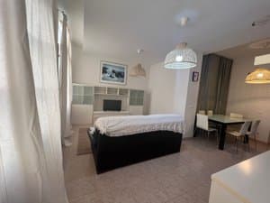 Sala de estar con sofá negro y comedor