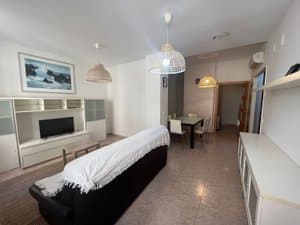Sala de estar con sofá y comedor al fondo