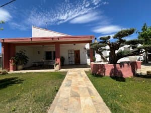 Chalet de una planta con porche y jardín de césped