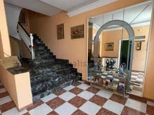 Recibidor con escalera de mármol y espejo