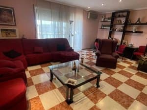 Salón con sofá rojo y mesa de cristal