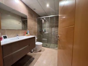 Baño con ducha de mampara y mueble de lavabo
