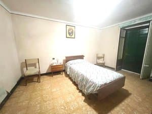 Dormitorio con cama individual y puerta de madera
