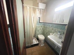 Baño con ducha, inodoro y lavabo