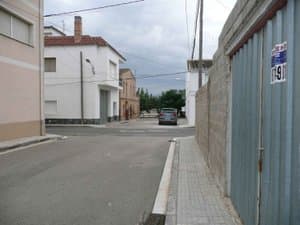 Calle junto al solar con casas alrededor