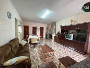 Salón con sofá, mueble de televisión y comedor