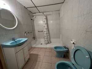 Baño con ducha, bidé y lavabo azul