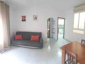 Salón con sofá gris y cojines rojos