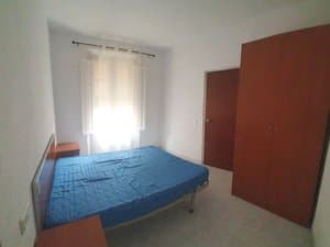 Dormitorio con cama de matrimonio y armario