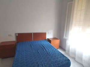 Dormitorio con cama y mesitas de noche
