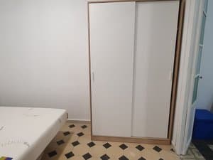 Armario de puertas correderas junto a la cama