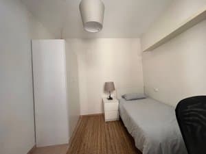 Habitación con cama individual y armario blanco