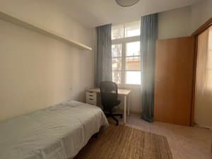 Habitación con cama, escritorio y ventana