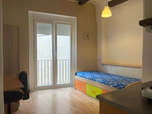 Estudio con cama, escritorio y puerta al balcón
