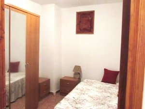 Dormitorio con cama y armario de espejo