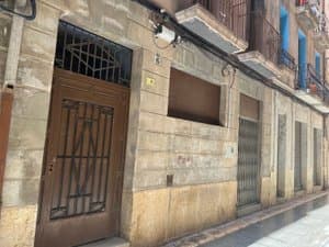 Planta baja con puerta de hierro y persiana