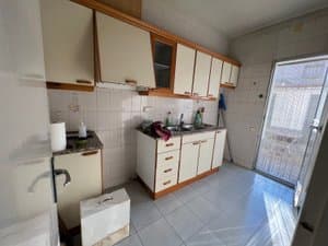 Cocina con muebles blancos y salida al patio