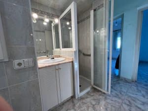 Baño con ducha de mampara y mueble de lavabo