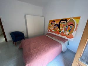 Habitación con cama doble y cuadro colorido