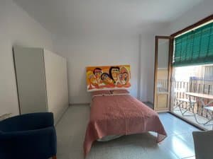 Habitación con butaca y salida al balcón