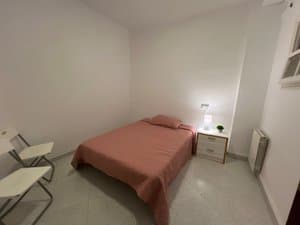 Dormitorio con cama y mesita