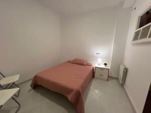 Dormitorio con cama y sillas plegables