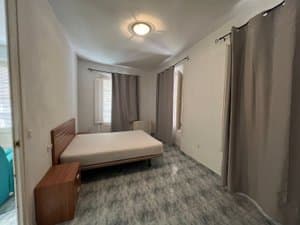 Dormitorio con cama de matrimonio y cortinas