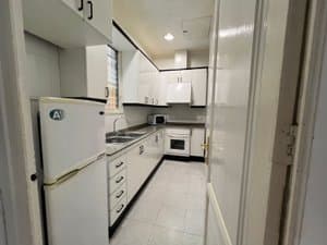 Cocina alargada con muebles blancos