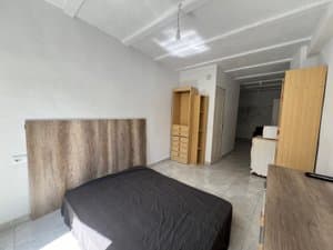 Estudio con cama doble y muebles de madera