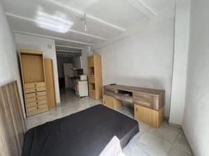 Estudio con cama, cómoda y mueble de televisión