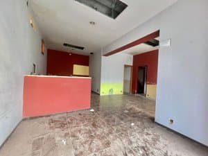 Planta baja diáfana con mostrador rojo