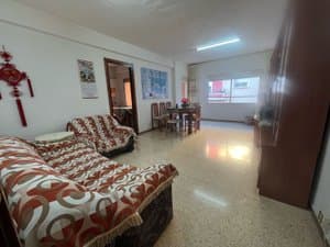 Salón comedor alargado con sofá y ventanal