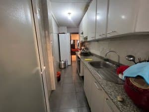 Cocina alargada con muebles blancos