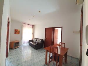 Salón comedor con sofá y mesa de madera