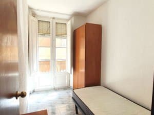 Dormitorio con cama individual y balcón