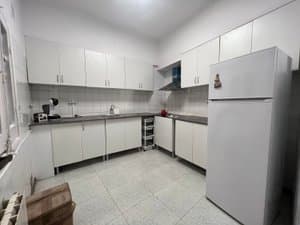 Cocina con muebles blancos y frigorífico