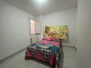 Habitación con cama y cuadro colorido